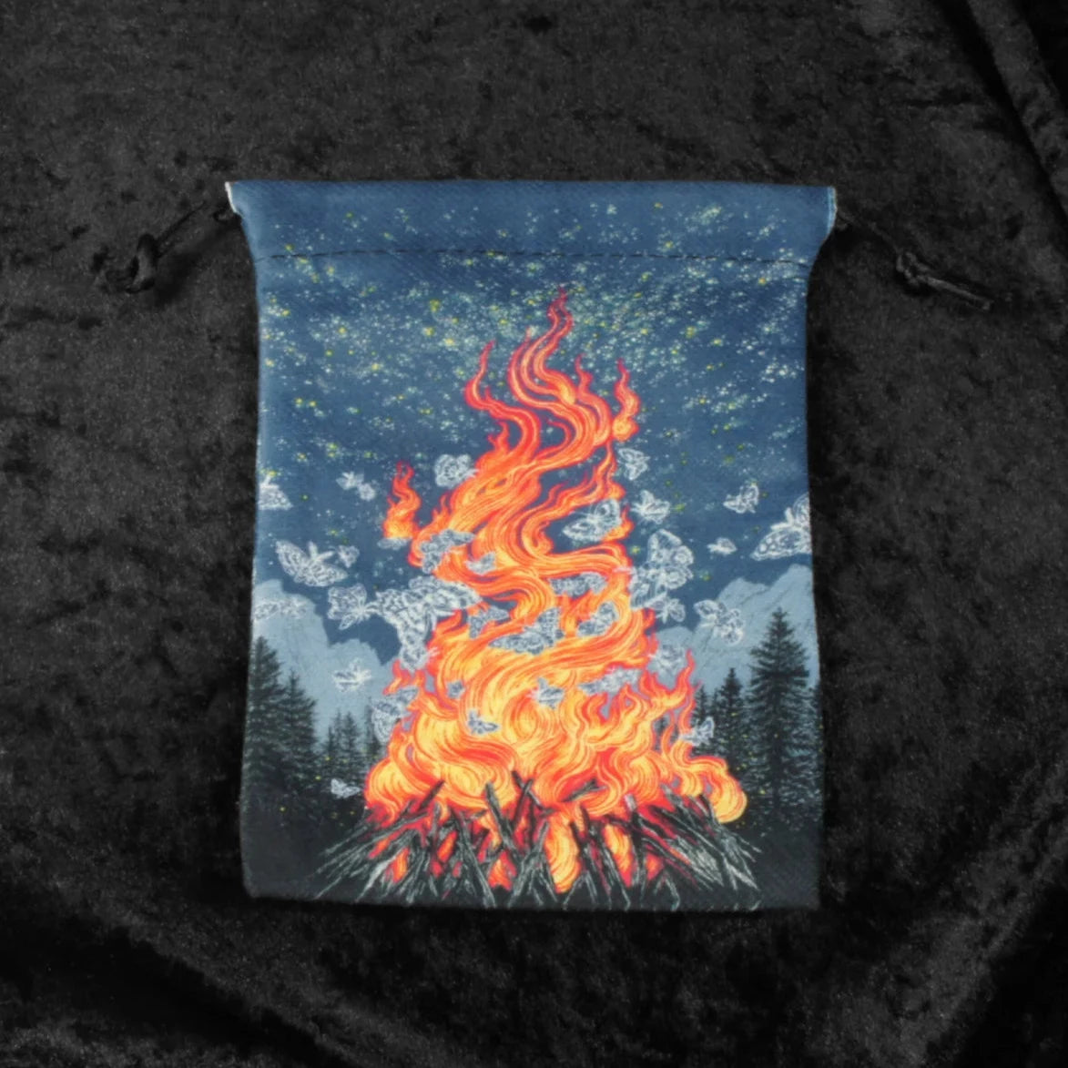 The image showcases the Adventurer's Rest Fantasy Drawstring Dice Bag in all its glory. The bag features a vibrant illustration of a campfire at its center, surrounded by intricate patterns reminiscent of ancient runes. The drawstring closure is visible at the top of the bag, adding an element of functionality to its captivating design.